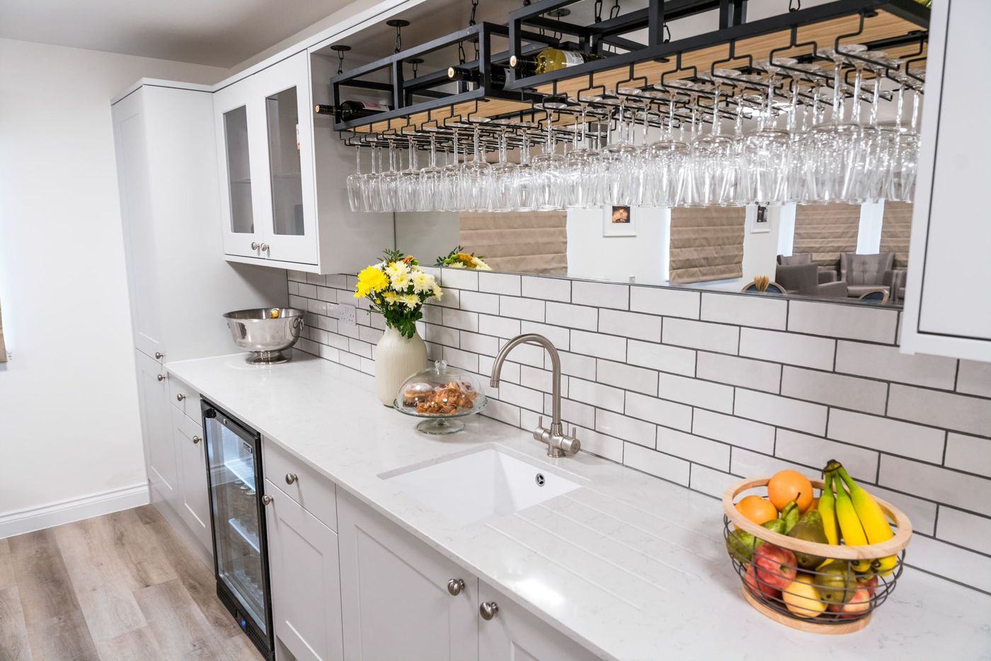 A bright kitchenette with fresh flowers, pastries and a bowl of fruit